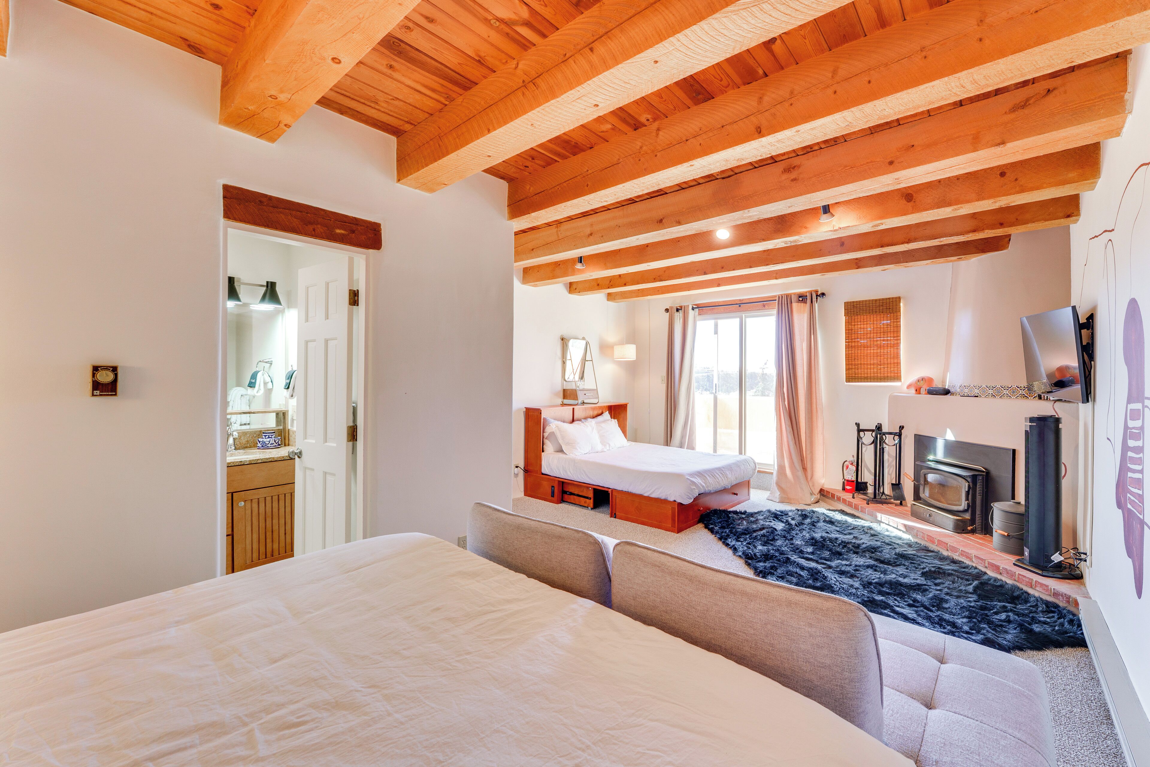 Une chambre à coucher avec un grand lit, un canapé, une cheminée et un téléviseur.