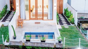 Eine moderne Villa mit Pool, Essbereich und Schlafzimmer mit Schiebegläsern.