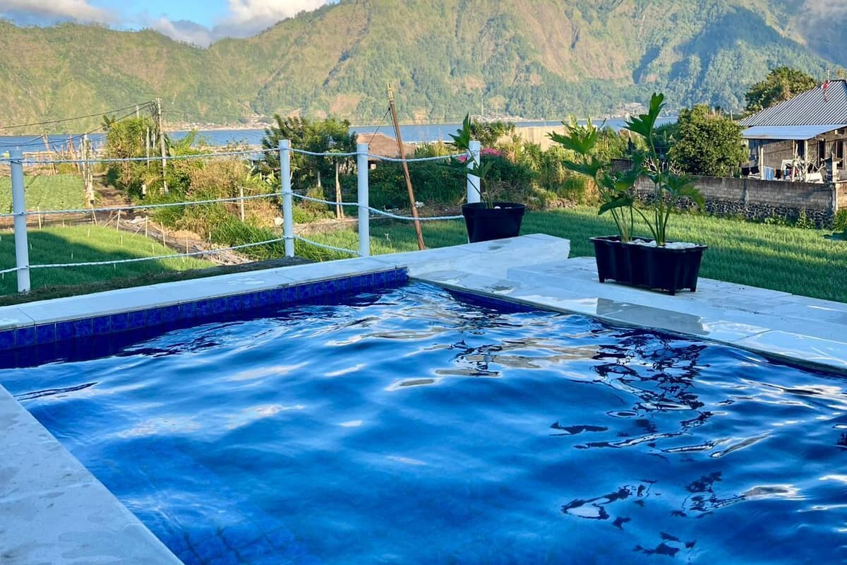 Une piscine avec vue sur les montagnes et un ciel dégagé.