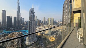 A high-rise building with a view of a cityscape, including a prominent tower and a mall. - Royale Highend  Burj and Fountain View (Dubai)