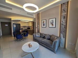 Un salon moderne comprenant un canapé, une table basse et un coin repas avec des chaises.