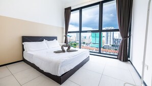 Ein Hotelzimmer mit großem Bett, Blick auf die Stadt durch ein großes Fenster und modernem Design.