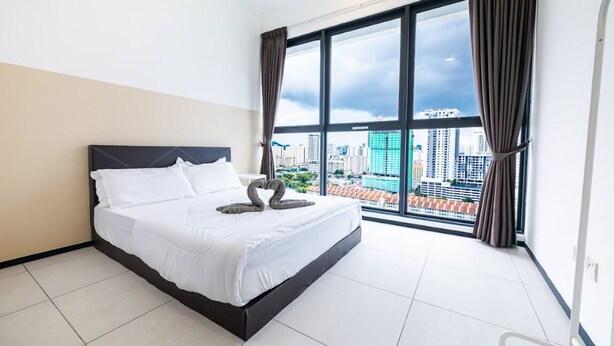 A hotel room with a large bed, a view of the cityscape through a large window, and a modern design.