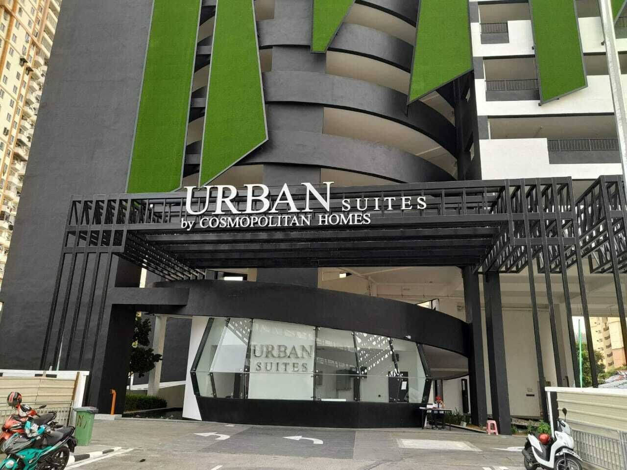 A modern building with a sign reading "URBAN SUITES by Cosmopolitan Homes".