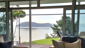 A modern living room with two sofas, a coffee table, and a view of a lake.