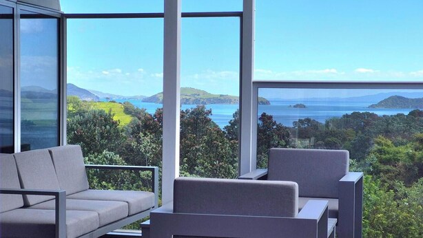 A modern outdoor seating area with a view of a coastal landscape.