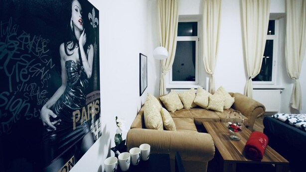 Una sala de estar con un sofá, una mesa de centro y un cartel en la pared.