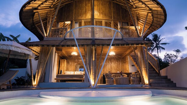 A wooden villa with a curved roof, a balcony, and a pool area. - Damuh Alam (Sukasada)