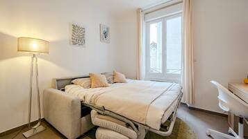 1 habitación, escritorio y tabla de planchar con plancha