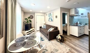 A modern living room with a sofa, TV, and dining area. - 1-bedroom cozy private entry suite.
Pet-friendly (Maple Ridge)