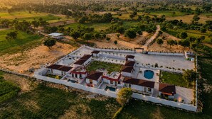 A large estate with multiple buildings, a swimming pool, and a surrounding landscape. - Jangal Resort - Sikar Road Jaipur (Jalsu)