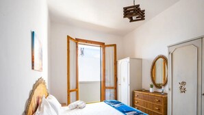 Ett hotellrum med en säng, en garderob, en spegel och ett fönster.