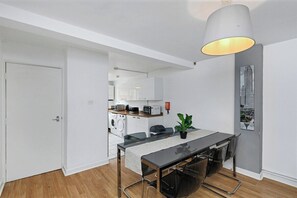 A modern kitchen with white cabinets and a dining area with a table and chairs.