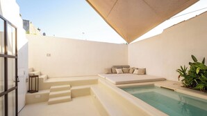 Ein moderner Poolbereich im Freien mit einer Liege und Treppen zum Pool.