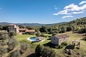 A stone villa with a swimming pool, surrounded by lush greenery and hills. - Il Gabbro, Luxury by Geco Vacation Rentals (Casole D'elsa)