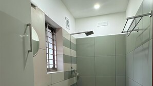 Une salle de bain moderne équipée de toilettes, d’un lavabo et d’une zone douche.