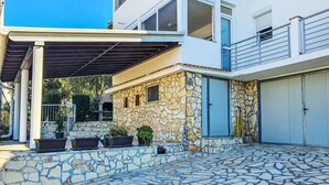 A modern two-story house with a stone facade, a covered patio, and a stone-tiled courtyard. - Apartment Ana by Interhome (Sv. Filip i Jakov)
