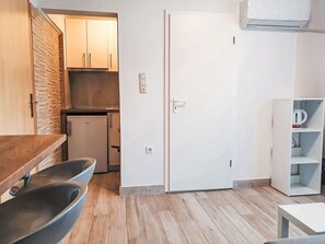 Eine kleine Küche mit Holzschränken, einem eingebauten Geschirrspüler und einem weißen Kühlschrank.