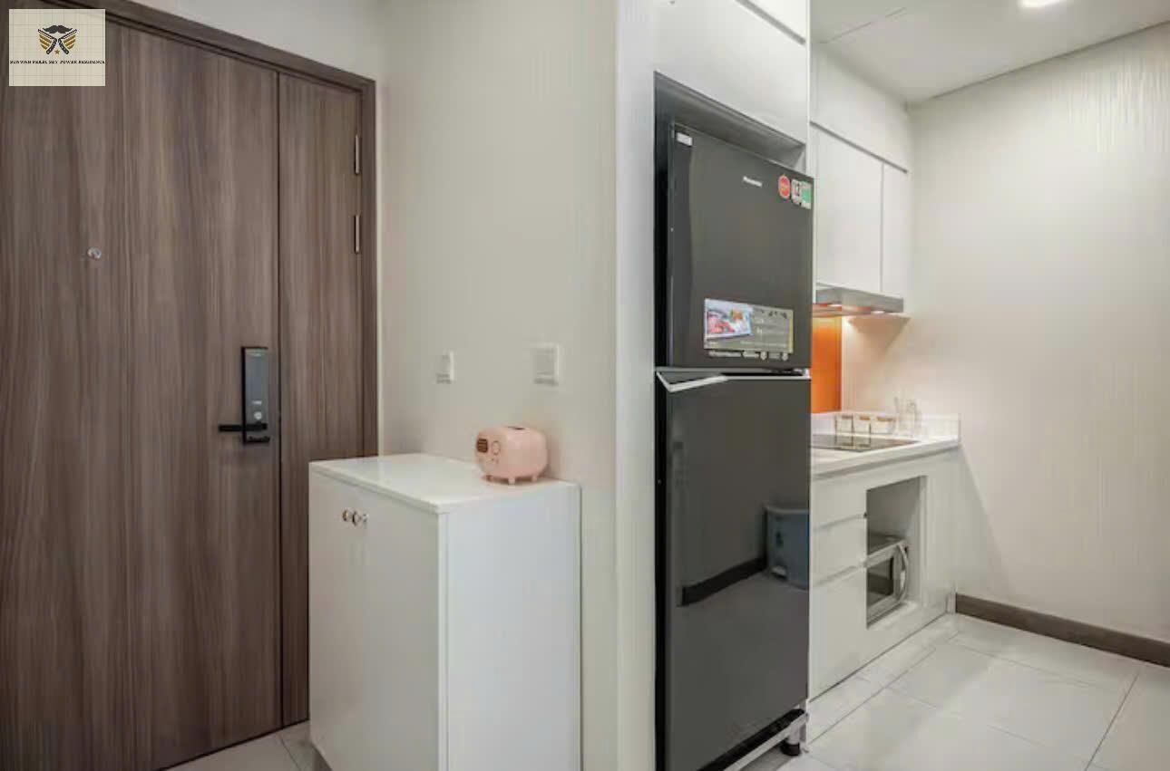 A compact kitchen with a refrigerator, a microwave, and a small countertop.