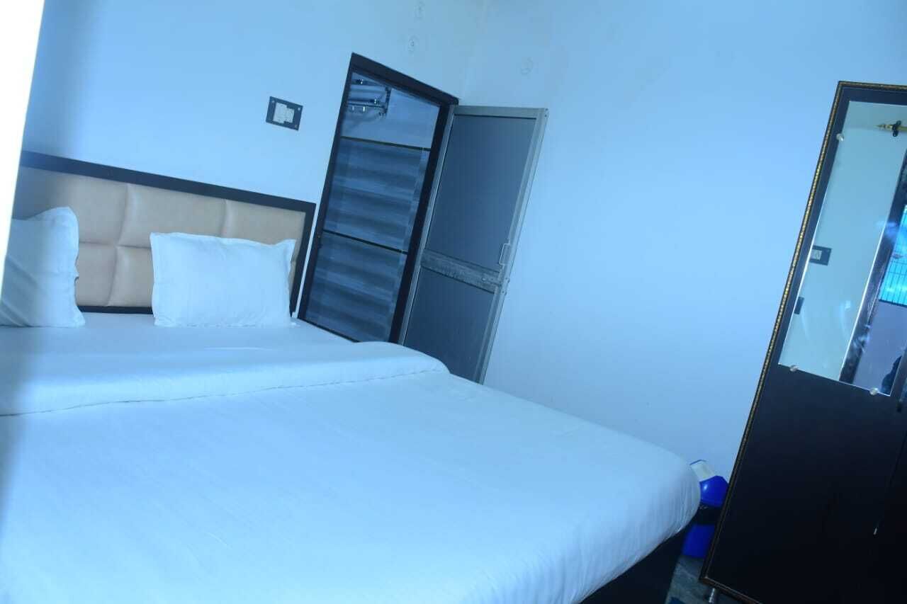Una habitación de hotel con cama, armario y espejo.
