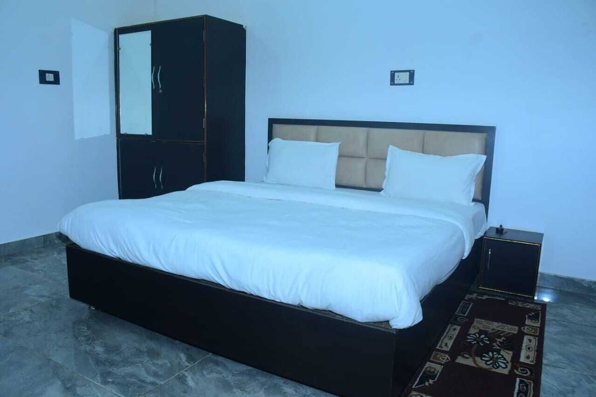 Ein Schlafzimmer mit einem großen Bett, einem Kleiderschrank und einem kleinen Tisch.