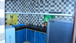 Eine Küche mit blauen Schränken, einer schwarzen Arbeitsplatte und einer karierten Spritzschutzwand.