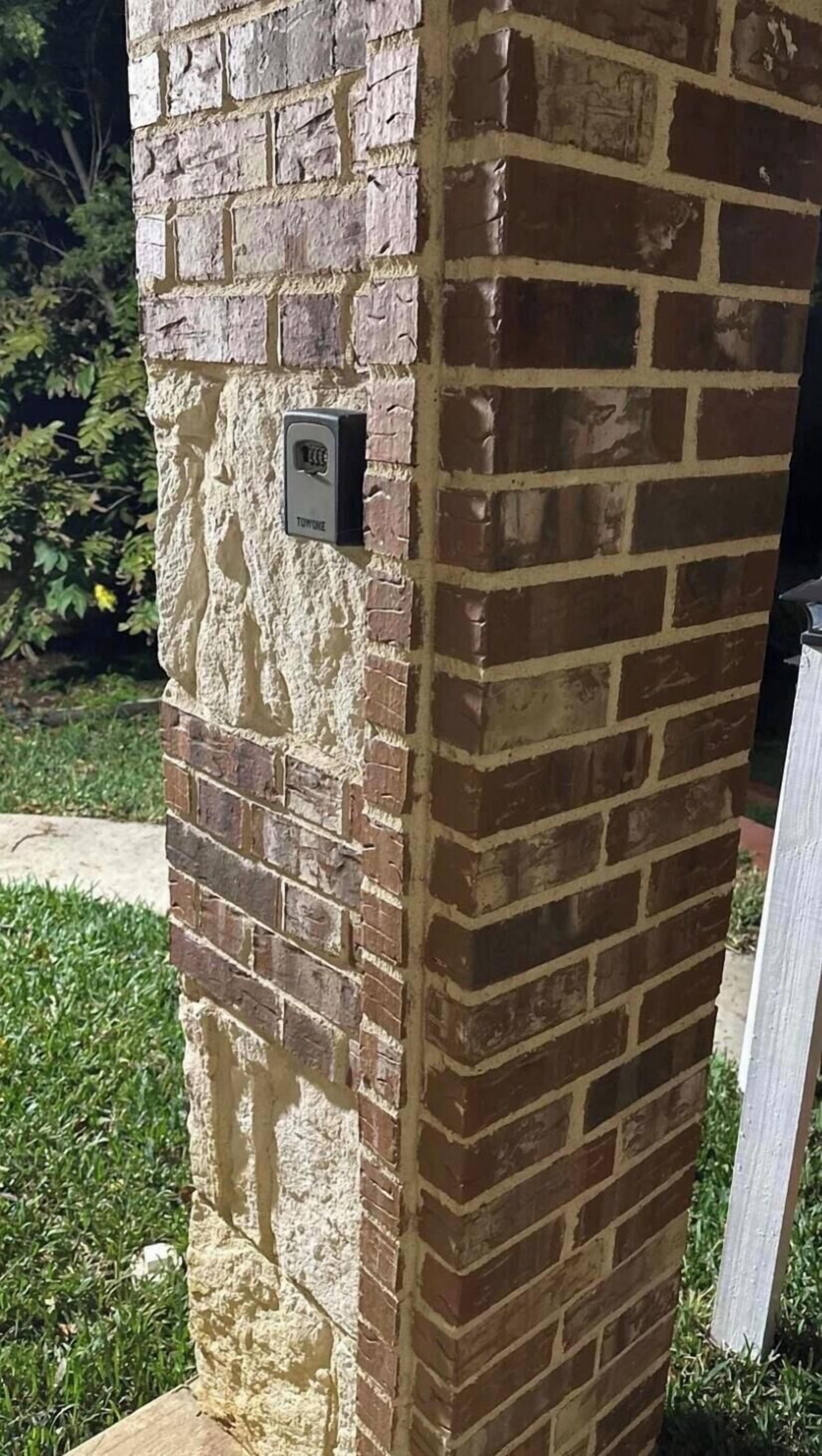A brick pillar with a security camera.