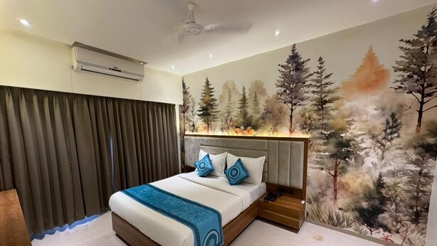 A bedroom with a bed, a nightstand, an air conditioning unit, and a ceiling fan.