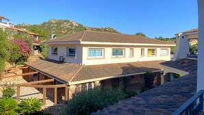A two-story house with a tiled roof, a balcony, and a stone foundation. - Charming two-room apartment of approximately 40 square meters with a 25 square meter covered veranda, located on the ground or first floor.It comprises a living room with a fully equipped kitchenette and a sofa bed, a bedroom with a double bed, and a bat (Porto Rotondo)