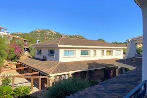 A two-story house with a tiled roof, a balcony, and a stone foundation. - Charming two-room apartment of approximately 40 square meters with a 25 square meter covered veranda, located on the ground or first floor.It comprises a living room with a fully equipped kitchenette and a sofa bed, a bedroom with a double bed, and a bat (Porto Rotondo)