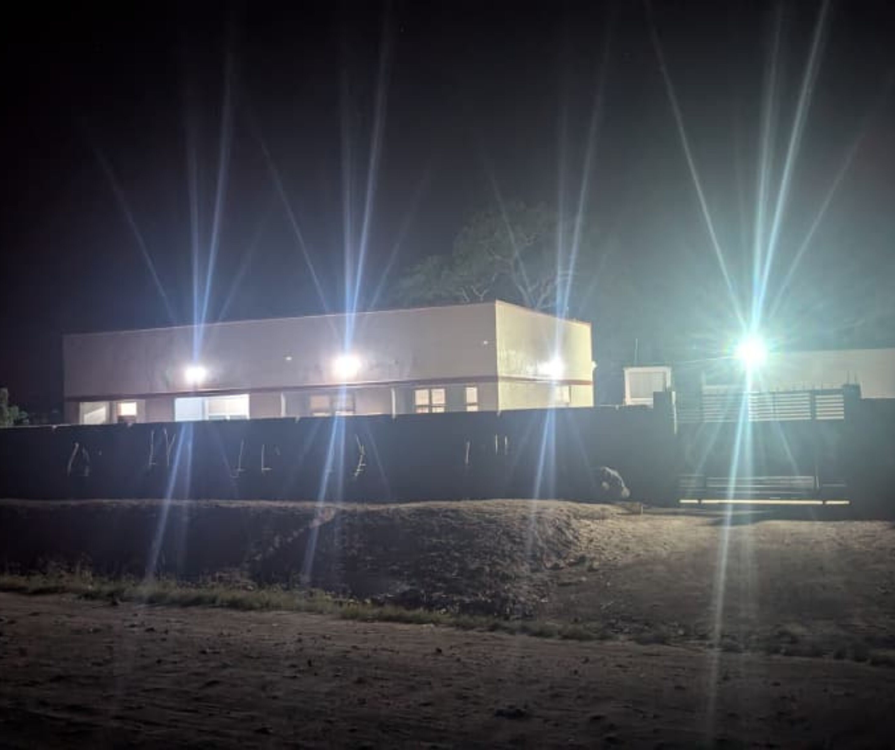 A modern building with multiple illuminated windows at night.