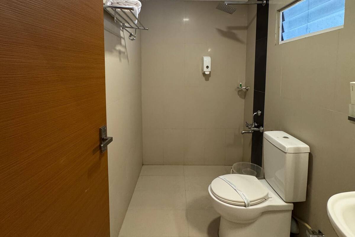 Un baño pequeño y limpio con inodoro, lavabo y ducha.