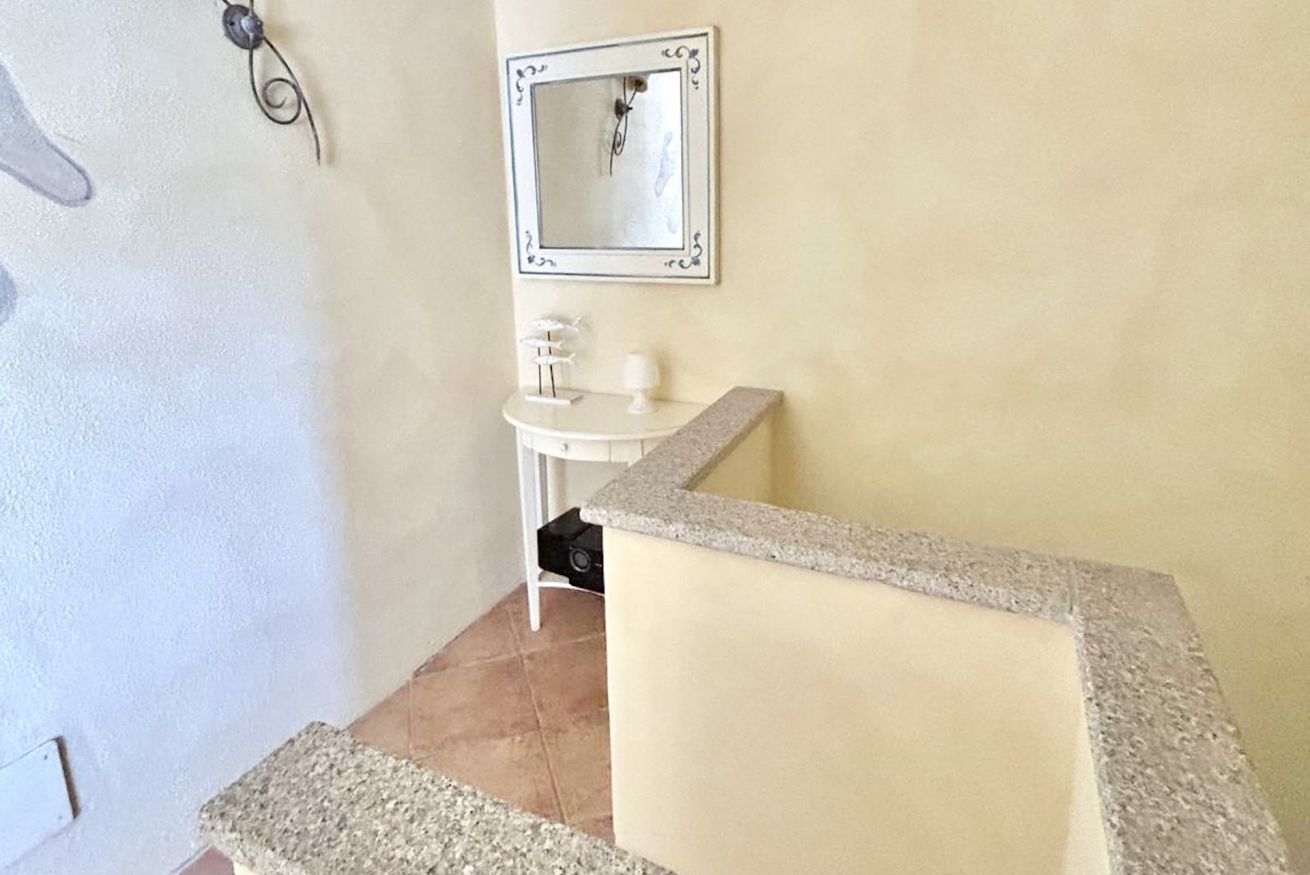 A bathroom with a white sink, a mirror, and a granite countertop.