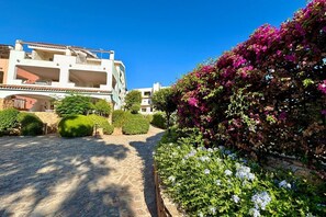 A courtyard with stone flooring, surrounded by well-maintained hedges and flowering plants. - Characterful and spacious two-level apartment located on the first floor.On the first floor, there is a studio apartment of approximately 30 square meters with a 25 square meter covered veranda. It consists of a single room with a double bed and an equip (Porto Rotondo)