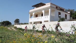 Un b âtiment blanc doté d’un balcon et d’un toit en pente.