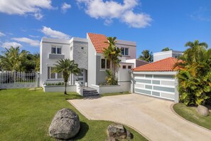 Ein modernes, zweigeschossiges Haus mit weißer Fassade, rotem Ziegeldach und Garage.