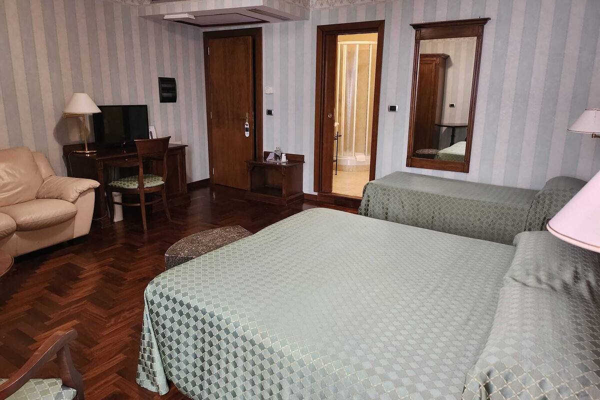 Camera tripla | Una cassaforte in camera, una scrivania, tende oscuranti