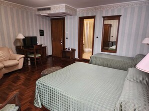 Camera tripla | Una cassaforte in camera, una scrivania, tende oscuranti