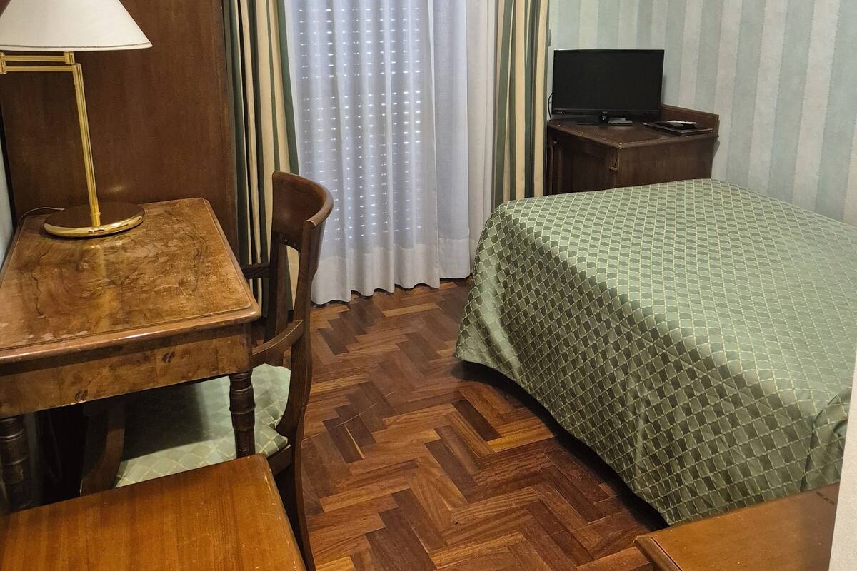 Camera singola | Una cassaforte in camera, una scrivania, tende oscuranti