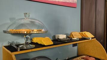 Buffet de café da manhã com diversos alimentos e uma placa indicando a distância até Appia.