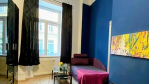 Ein modernes Schlafzimmer mit einem großen Bett, einer Couch, einem kleinen Tisch und einem Bild an der Wand.