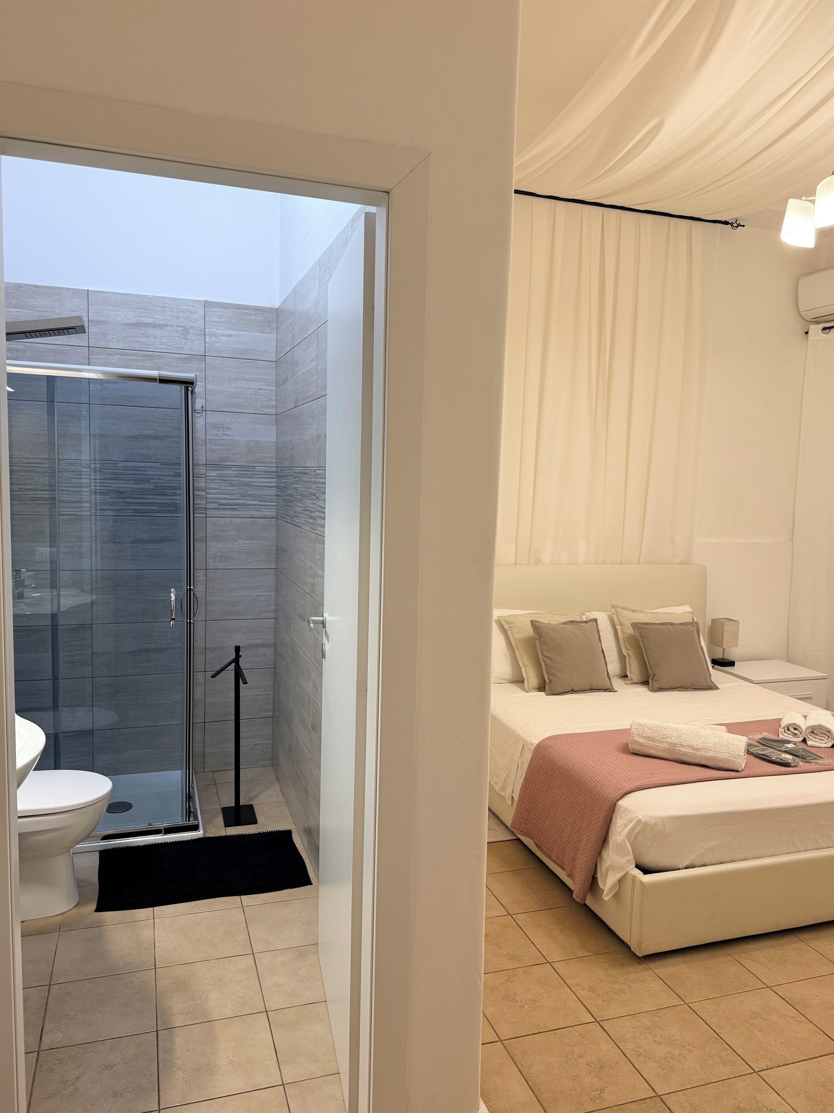 A modern bathroom with a glass shower enclosure, a toilet, and a sink.