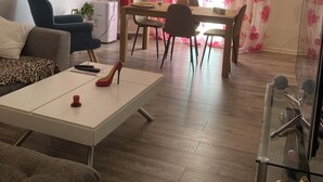 Una sala de estar con un sofá, una mesa de centro y un comedor con mesa y sillas.