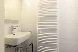 Ein Badezimmer mit Waschbecken, Spiegel und Handtuchhalter.