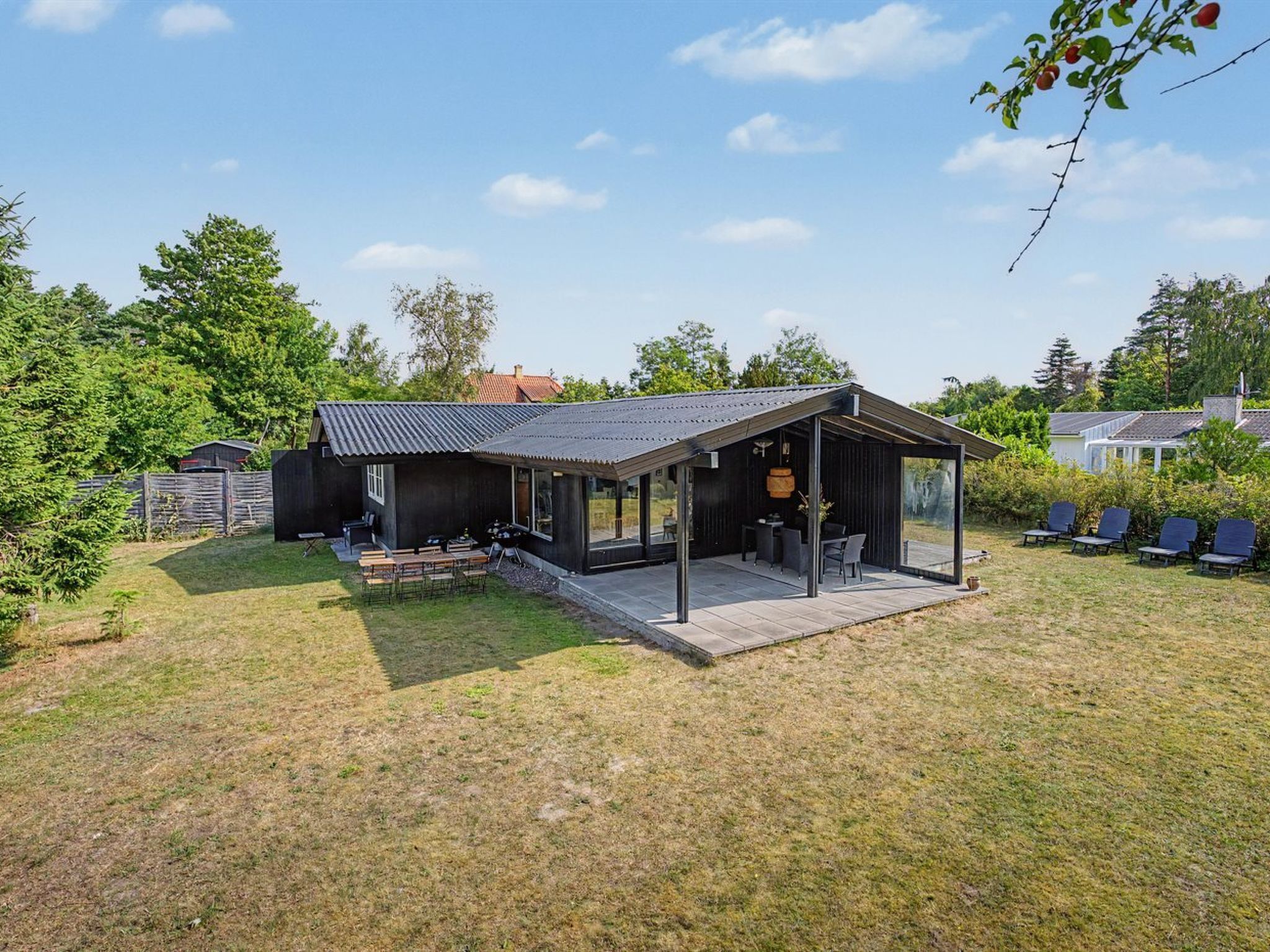 A modern outdoor dining area with a covered patio and a seating arrangement.