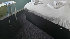 A hotel room with a bed, a desk, a chair, a window, and a shelf. - 2 Budget En-Suite Rooms with Shared Kitchen (Coventry)