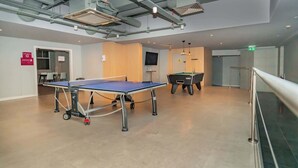 A spacious indoor area with a ping pong table, a pool table, and a television on the wall. - 2 Budget En-Suite Rooms with Shared Kitchen (Coventry)