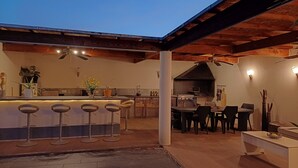 Une terrasse extérieure dotée d’un bar, de coins salon et d’un barbecue.