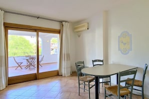 A room with a sliding glass door leading to a balcony with outdoor furniture. - Charming three-room apartment of approximately 60 square meters with a 25 square meter covered veranda, located on the ground or first floor.It comprises a living room with a fully equipped kitchenette and a sofa bed, a bedroom with a double bed, a secon (Porto Rotondo)