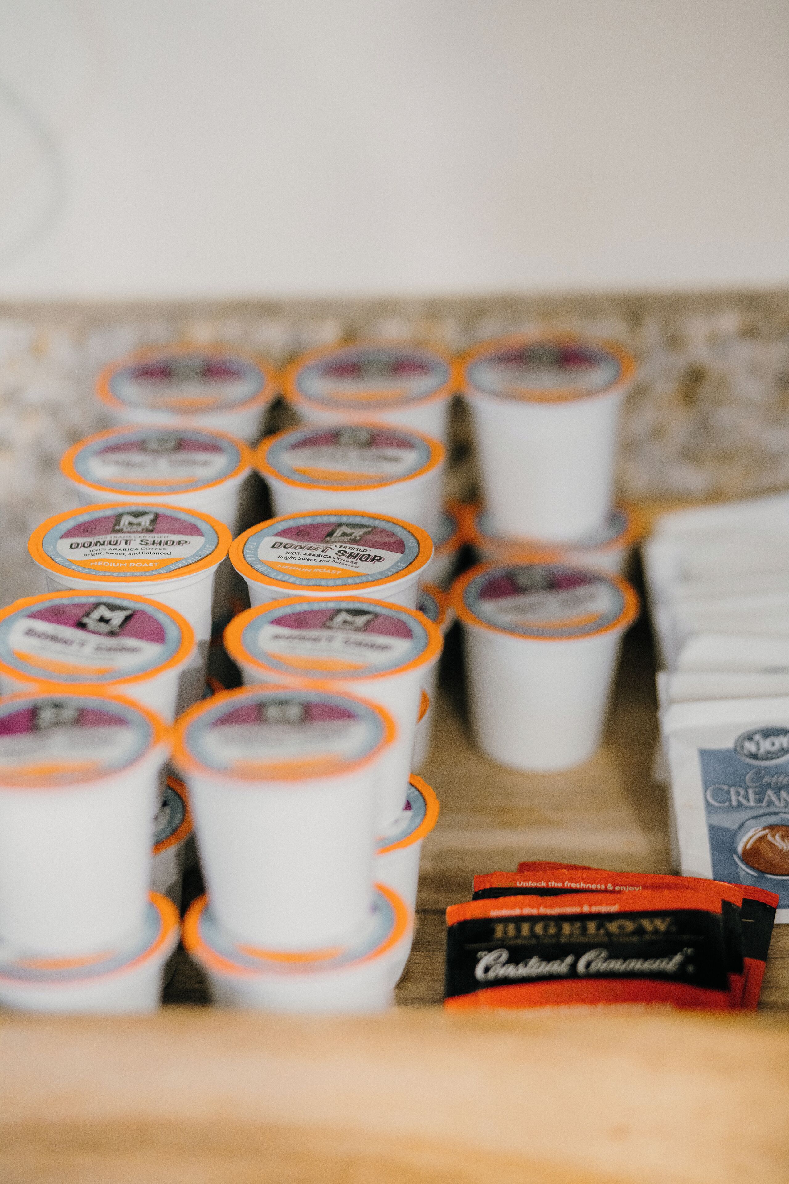 Une sélection de produits à base de café, comprenant un paquet de café de la marque « Donut Shop » et un café de la marque « RIGELLOW ».